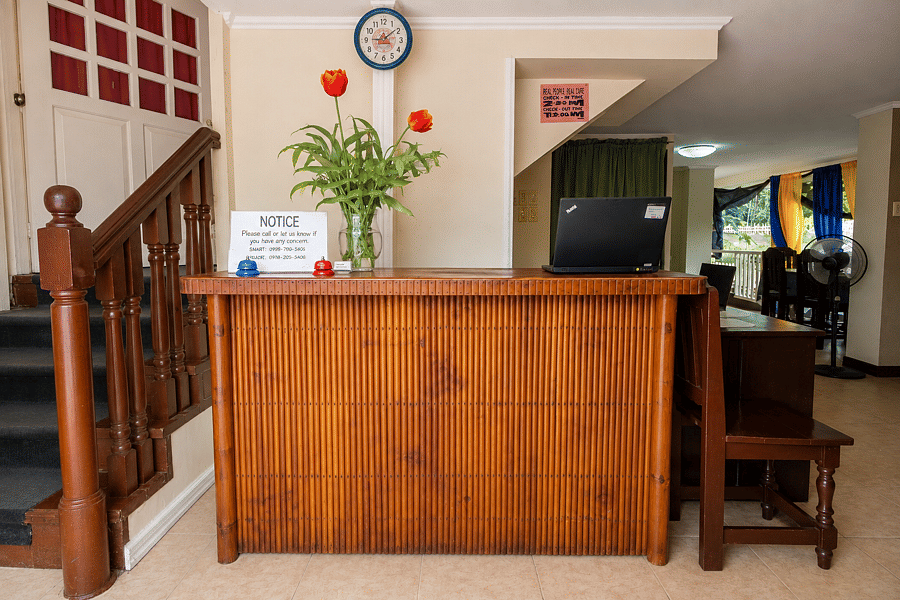 Front desk reception with clock and notice board at Pecan Pension House